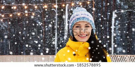 winter holidays and people concept - happy young woman over ice skating rink background