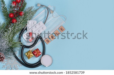 Christmas medical background. Stethoscope, medical mask, pills, heart, Christmas tree, gift box. Health concept in the context of coronavirus.Copy space fot text. Sale.Happy new year!