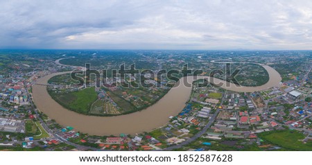 Aerial view of buildings with curve of Chao Phraya River. Cha Choeng Sao skyline near Bangkok, Urban city in downtown area at sunset, Thailand.