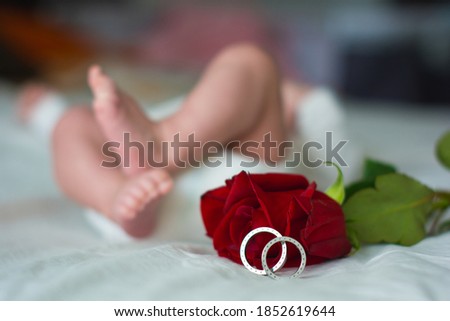 Feet of a newborn and his parents wedding rings. Legs of a newborn baby with mom and dad's wedding ring. Happy Family concept. Royalty-Free Stock Photo #1852619644