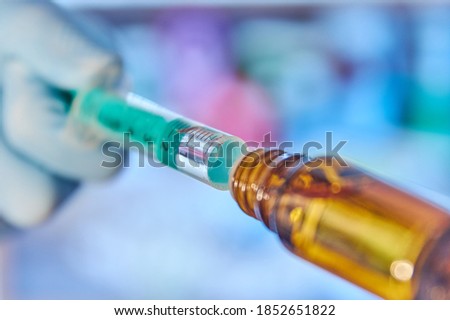 Closeup of a syringe with vaccine. Close up of a vial with vaccine. Coronavirus treatment. Coronavirus vaccine. Covid-19 vaccine. Moderna Biontech Pfizer Astrazeneca Curevac Novavax. Royalty-Free Stock Photo #1852651822