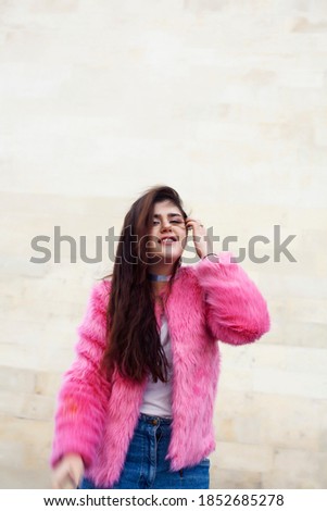 young cute girl teenager in pink fur coat gesturing hanging around outdoor , lifestyle people concept