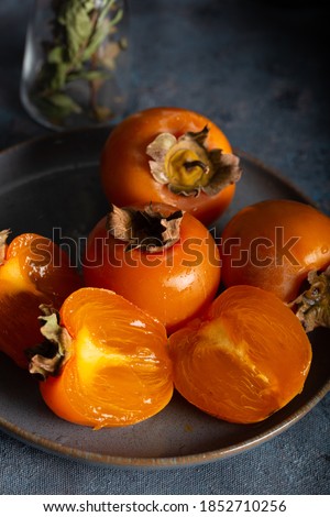Slices of fresh persimmon. Autumn still life of fresh kaki. Royalty-Free Stock Photo #1852710256