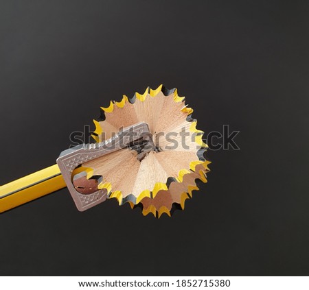 Pencil sharpener by sharpening a pencil. Concept of effort, starting, learning, studying, teaching. Background image for study centers, learning, teachers, classes. Top view.
