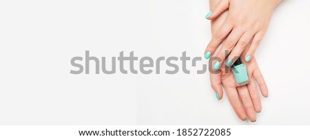 Female hands with manicure on wooden background.