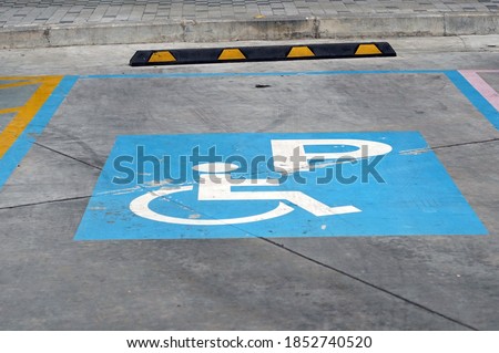 A blue parking sign for wheelchair in the carpark.