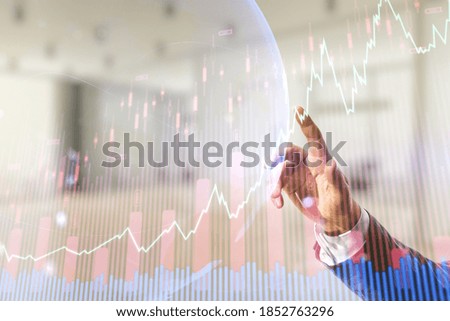Man hand working with abstract creative financial graph and world map on blurred office background, forex and investment concept. Multiexposure