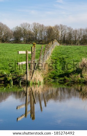Reflections of old wooden fence off the Leeds/ Liverpool canal on a beautiful spring day.
