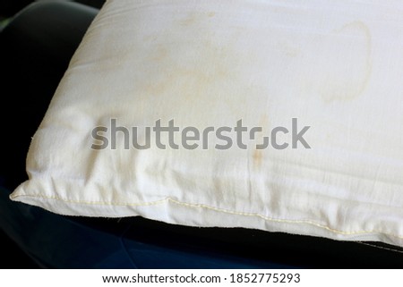 White old pillow with dirty stain. Selective focus