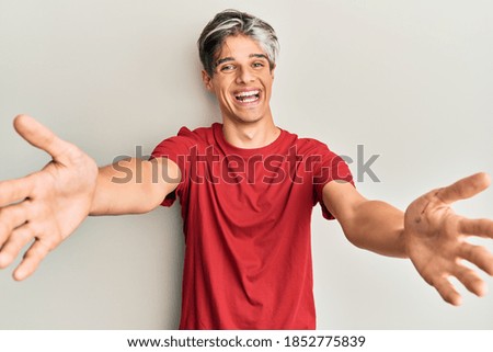 Young hispanic man wearing casual clothes smiling cheerful offering hands giving assistance and acceptance. 