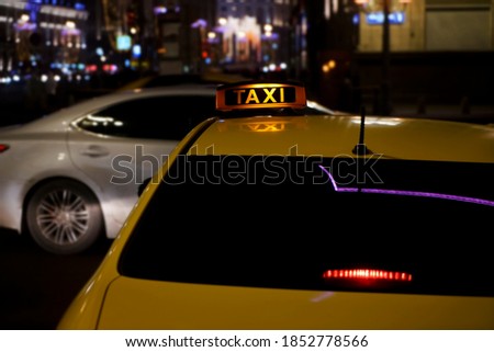 yellow taxi sign on cab car at evening or night in the city street. Moscow, Russia.