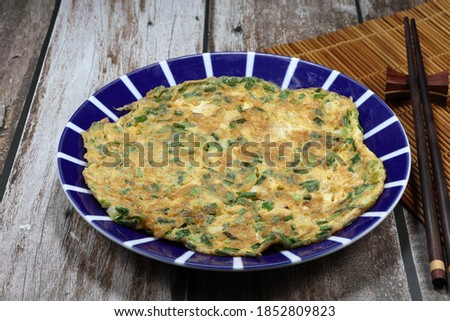 Deep fried egg with sliced spring onion on the plate. Famous traditional comfort menu in the morning. 