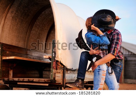 Portrait of kissing a guy and girl in cowboy hats Royalty-Free Stock Photo #185281820