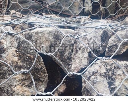 Stone gabion wall. Gabion - stones in wire mesh. Popular element of design for garden landscaping and erosion control