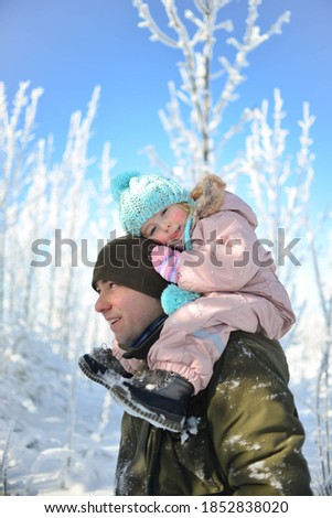 Happy family enjoys walking through the snowy forest, winter fun.