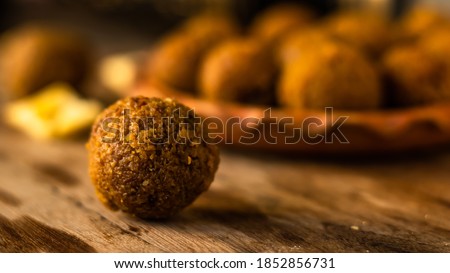 A mouth-watering Coconut naru, Bengali traditional sweets of diwali , placed on a wooden surface on the occasion of Diwali with other sweets arranged around it. Royalty-Free Stock Photo #1852856731