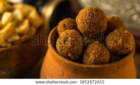 Delicious Bengali traditional sweets of Diwali, coconut naru, served in an earthen jar placed on an wooden table. Royalty-Free Stock Photo #1852872655