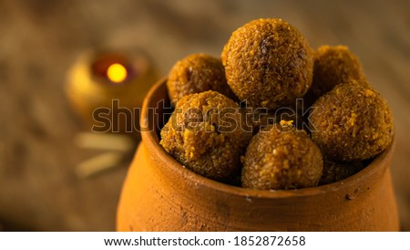 Delicious Bengali traditional sweets of Diwali, coconut naru, served in an earthen jar placed on an wooden table. Royalty-Free Stock Photo #1852872658