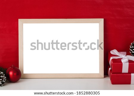 Blank wooden photo frame mockup template and christmas decoration on red blackground.