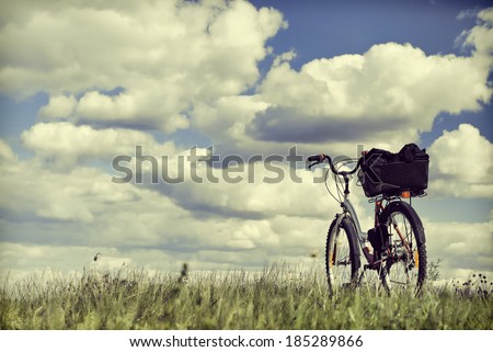 Bike on a grass against clouds. To a photo color toning is applied