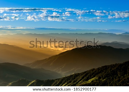 Landscape images of The morning sun, where a beautiful gold light covers the mountain range, And the light reflected on the clouds in the sky, to nature background concept.