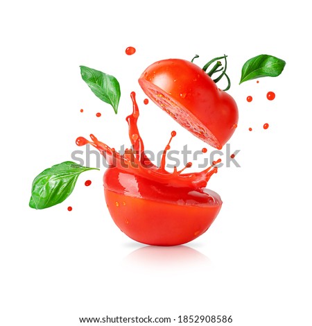 Splashing tomato juice with flying basil leaves isolated on white. Design element for product label. Royalty-Free Stock Photo #1852908586