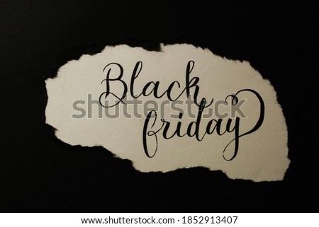 Ripped black piece of paper uncovers a writing saying "Black Friday"