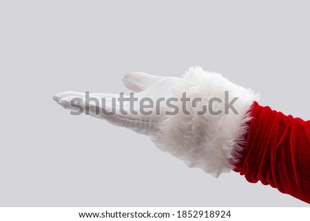 Merry Christmas, the season of giving and Happy Holidays concept with Santa Claus hand stretched out in open palm gesture isolated on white background with clipping path cutout