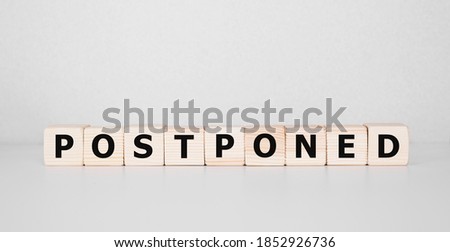 Postponed - words from wooden blocks with letters, postponed concept, top view background Royalty-Free Stock Photo #1852926736