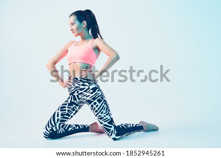 Sporty fit female in stylish sportswear posing in neon light. Healthy sport lifestyle. Advertising photo with copy space