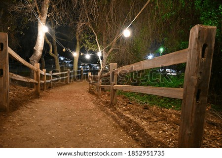 Wide shot of night light in the pathway with wood fence