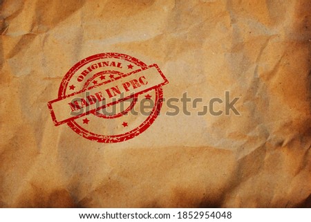 Made in PRC stamp printed on crumpled sheet of burnt paper. PRC Product Business, parcel, package, production logistics concept. Background with copyspace for design