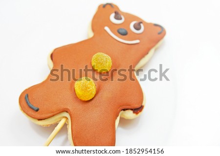 Closed up Teddy Bear shaped Gingerbread decorated with Yellow Candy on top, isolated on white background.
Selective focus.