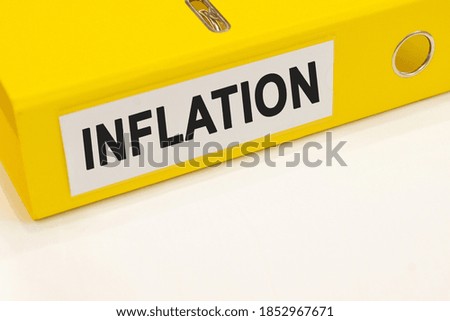 The word inflation on a white background with a yellow folder. Business concept