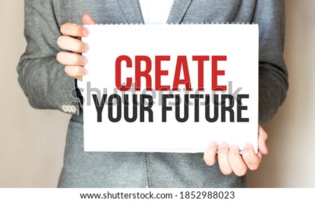 businessman holding a card with text create your future