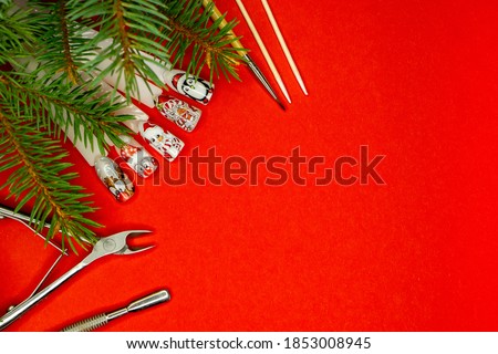  Christmas flat lay  on red bachground manicure tools  and  christmas nail picture . beauty salon concept .