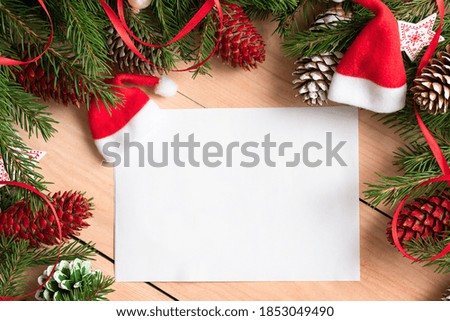 A piece of paper for text next to Christmas tree decorations.