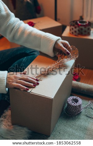 Attractive smiling woman preparing Christmas gifts for friends and family. New Year concept.