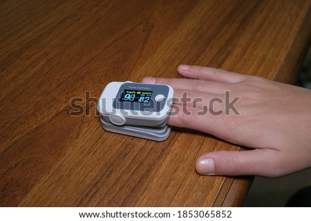 Young woman using pulse oximeter to measure oxygen saturation in covid19 pandemic disease,medical home monitoring treatment