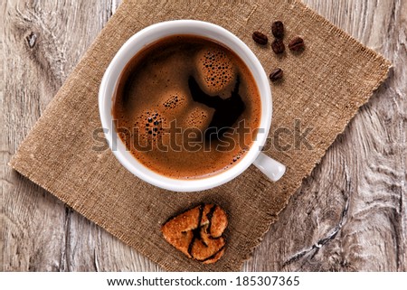 Coffee cup and saucer with coffee beans on a burlap 