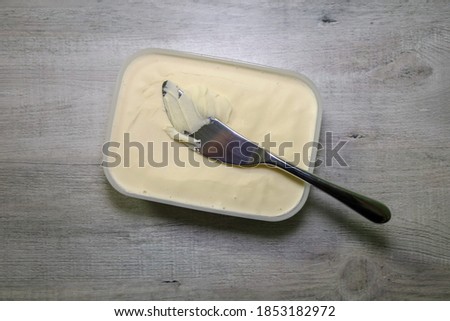 Top view of a container of non-dairy butter and a butter knife on top. Homemade vegan butter.