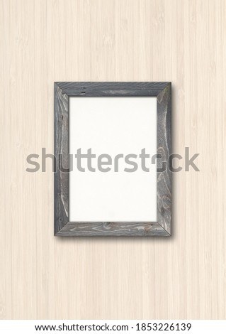 Old grey rustic wooden picture frame hanging on a wood wall. Blank mockup template