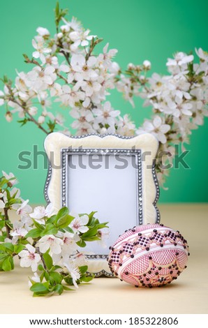 Plum cherry flowers and easter painted egg with photo frame with space for text 
