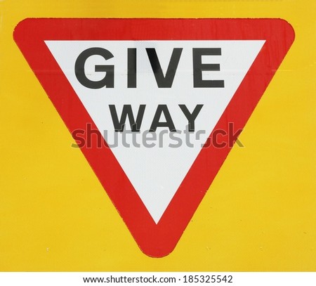 Give Way Sign Against A Yellow Background. 