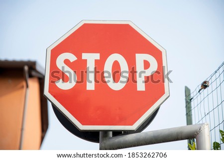 stop road sign with low houses and sky background