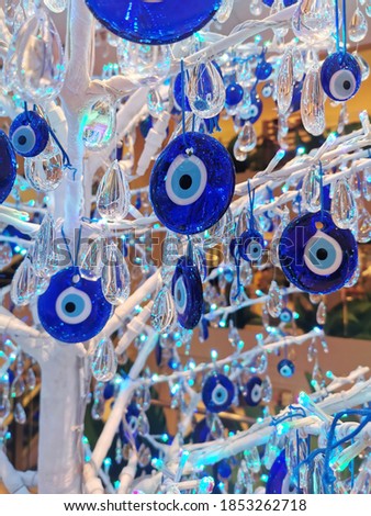 The branches of the tree decorated with the eye-shaped amulets - Nazars, made of blue glass and believed to protect against the evil eye. Turkish souvenirs. 