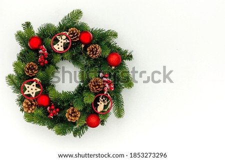 top view of decorative festive wreath with red a christmas toys on white