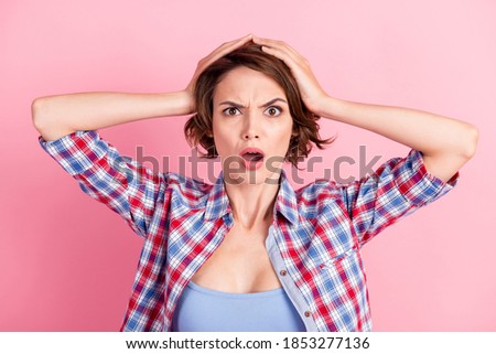 Photo portrait of shocked panicking woman holding head with two hands open mouth isolated on pastel pink colored background