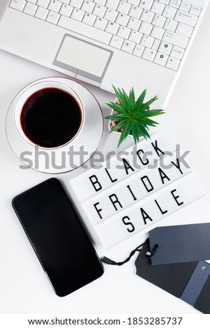 Black Friday concept. Laptop and coffee cup on white background. Online sale, discounts. Vertical format.