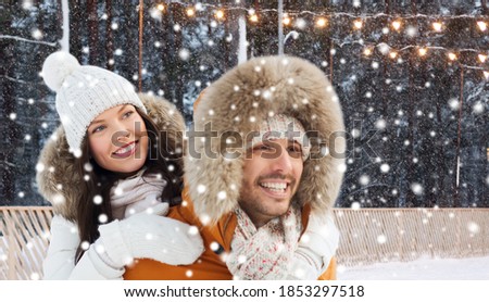 winter holidays, christmas and people concept - happy couple having fun over ice skating rink background